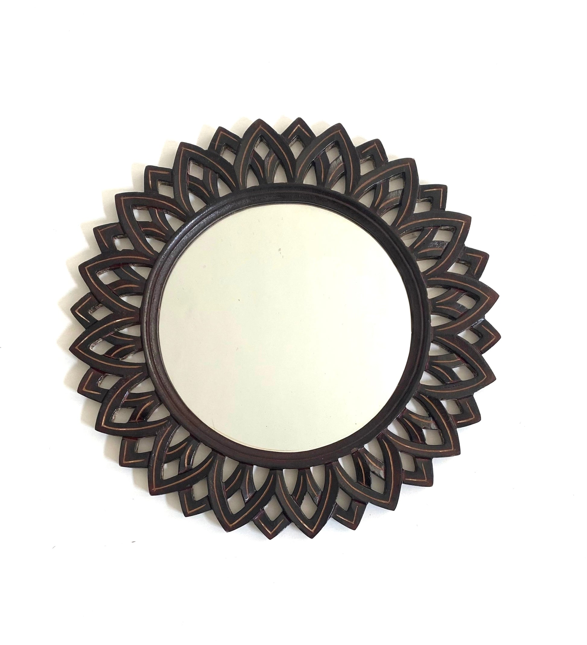 Decorative round mirror with intricate black floral frame on a white background