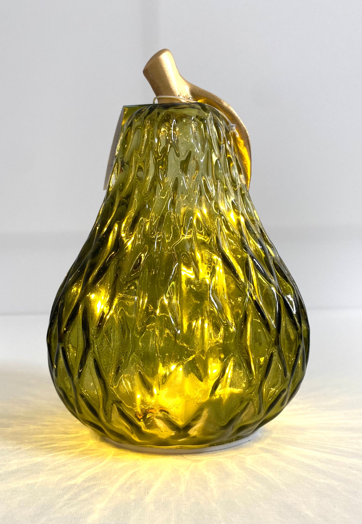 Decorative glass pear with gold top on a white background