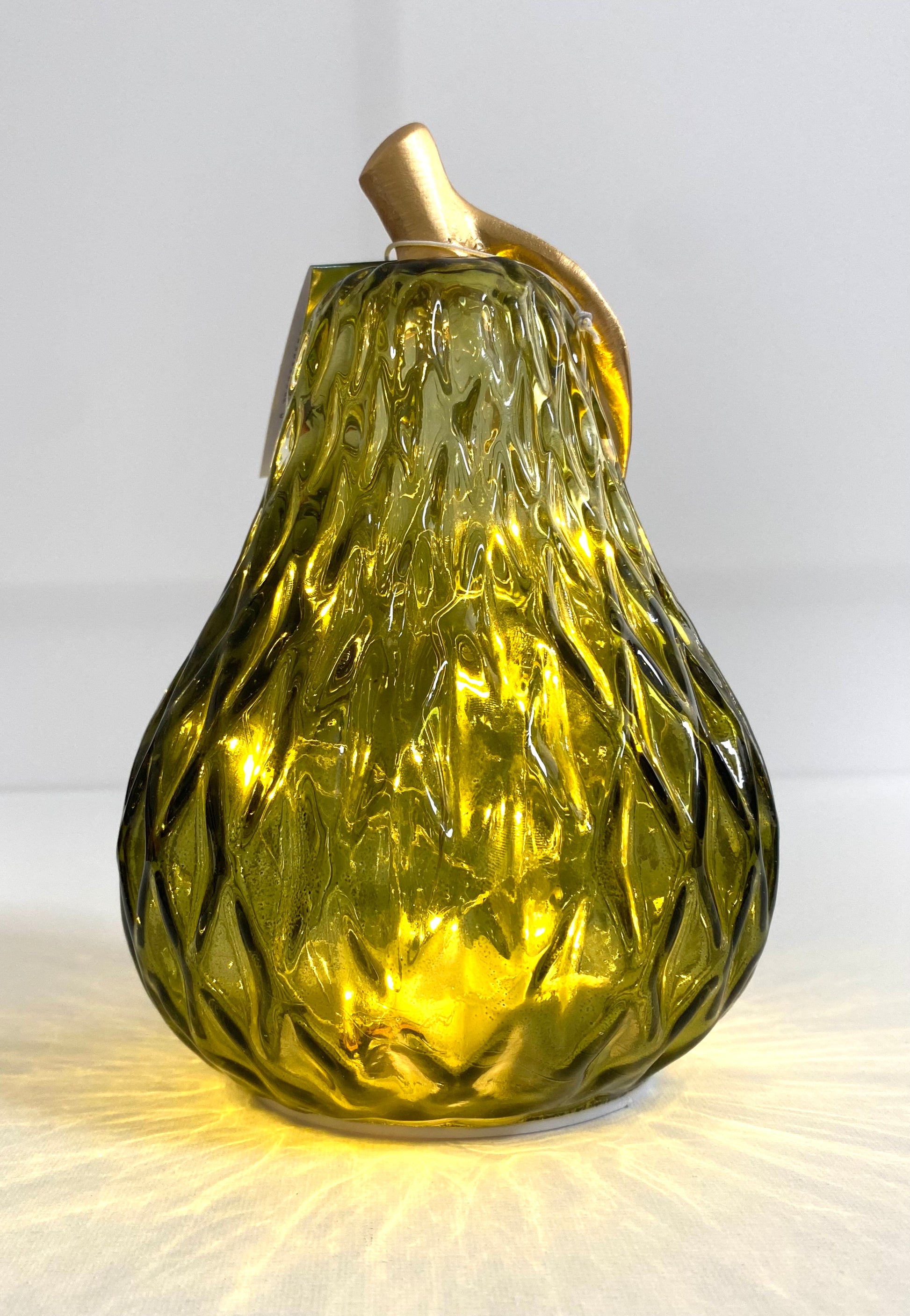 Decorative glass pear with gold top on a white background