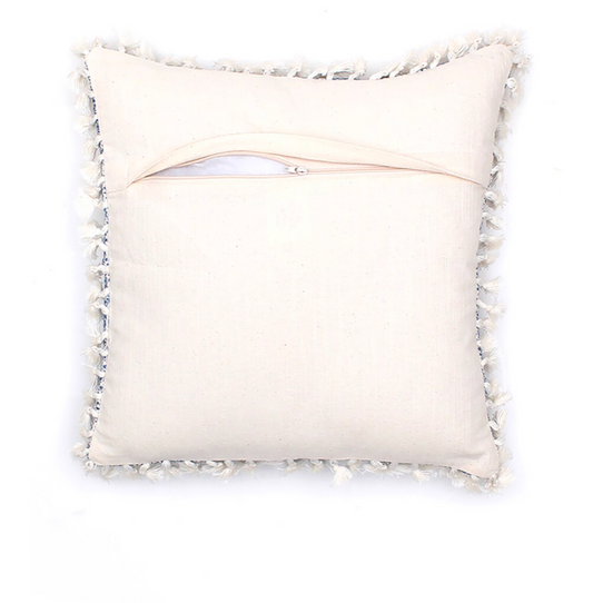 White pillow with decorative tassels on a white background